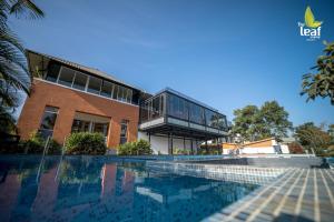 un bâtiment avec une piscine en face d'un bâtiment dans l'établissement The Leaf Munnar, à Munnar