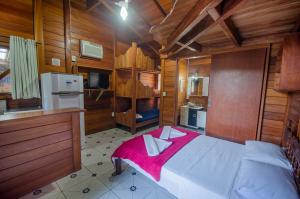 a bedroom with a large bed in a wooden room at Pousada Oceânica in Bombinhas