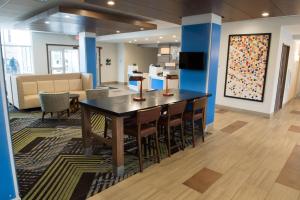 a conference room with a table and chairs and a couch at Holiday Inn Express & Suites - Louisville N - Jeffersonville, an IHG Hotel in Jeffersonville