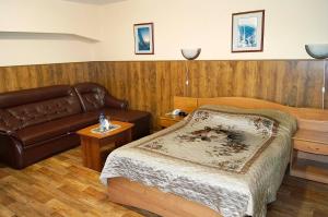 ウラン・ウデにあるYurta Mini Hotelのベッドルーム(ベッド1台、革張りのソファ付)