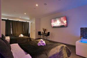 a hotel room with two beds and a tv on the wall at Wellness Suite Zeist in Zeist