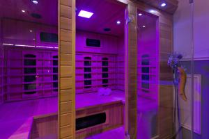 a walk in shower with purple lighting in a bathroom at Wellness Suite Zeist in Zeist