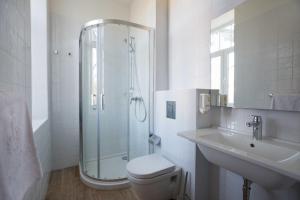a bathroom with a shower and a toilet and a sink at Hostel Link in Lovran