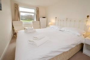 a bedroom with a white bed with white towels on it at 27 Thrang Brow, Chapel Stile in Chapel Stile