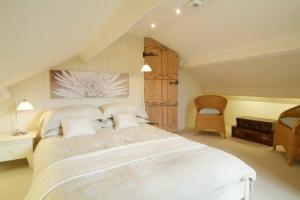 - une chambre avec un grand lit blanc et une chaise dans l'établissement Barnhowe, Elterwater, à Chapel Stile