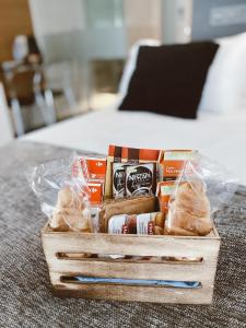uma caixa de madeira cheia de comida e pão numa cama em Salamanca Suites Libertad em Salamanca