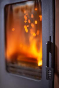 um close-up de um forno com um fogo nele em Sodyba Namelis medyje Anykščiuose em Anykščiai