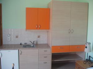 a kitchen with orange cabinets and a sink at Bel Mare in Agioi Apostoli