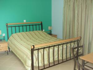 a bed in a bedroom with a green wall at Bel Mare in Áyioi Apóstoloi