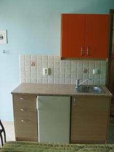 a kitchen with a sink and a white refrigerator at Bel Mare in Áyioi Apóstoloi