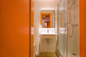 a bathroom with a sink and a shower at Hostel Link in Lovran