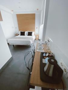 um quarto com uma cama e uma mesa com um candeeiro em Salamanca Suites Libertad em Salamanca