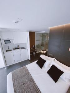 a bedroom with a large white bed with black pillows at Salamanca Suites Libertad in Salamanca