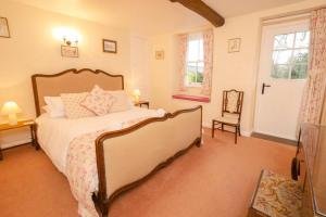 a bedroom with a bed and a chair in it at End Cottage, Chapel Stile in Chapel Stile