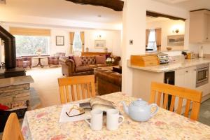 a kitchen and living room with a table with a tea set at End Cottage, Chapel Stile in Chapel Stile