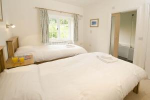 a bedroom with two beds and a window at Farra Grain, Little Langdale in Little Langdale