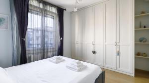 ein weißes Schlafzimmer mit einem Bett mit Handtüchern darauf in der Unterkunft Italianway - Colombo 4 in Villasanta