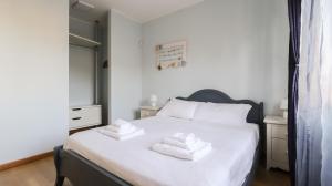 ein Schlafzimmer mit einem weißen Bett mit Handtüchern darauf in der Unterkunft Italianway - Colombo 4 in Villasanta + 20 Fotos