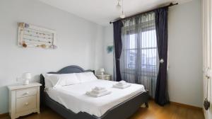 1 dormitorio con 1 cama con sábanas blancas y ventana en Italianway - Colombo 4, en Villasanta