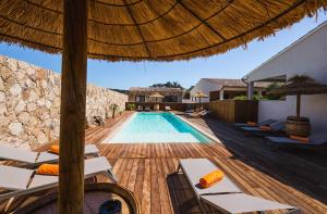 a swimming pool with lounge chairs and an umbrella at Résidence Petra d'Oro - Villa Chiappa in Porto-Vecchio