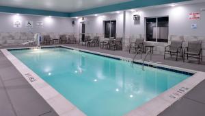 a large swimming pool with chairs and tables at Holiday Inn Express & Suites Lexington Midtown - I-75 by IHG in Lexington