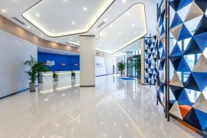 西安市にあるHoliday Inn Express Xi'an Intl Trade&Logistic Park, an IHG Hotelの幾何学的な壁のオフィスビルのロビー