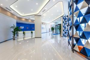 a lobby of an office building with a geometric wall at Holiday Inn Express Xi'an Intl Trade&Logistic Park, an IHG Hotel in Xi'an
