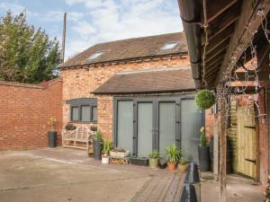 eine Garage mit grauen Türen und Topfpflanzen in der Unterkunft Bank House Barn in Shrewsbury