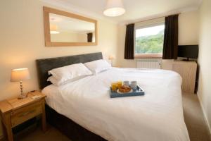 a hotel room with a bed with a tray of food on it at Lingmell Fell View, Chapel Stile in Chapel Stile