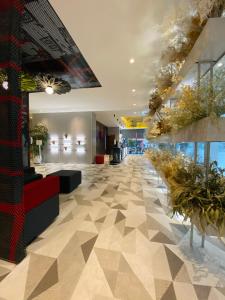 a lobby with a tile floor and plants at Ibis Kaunas Centre in Kaunas