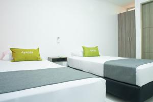 two beds sitting next to each other in a room at Hotel Ayenda House Concepción 1317 in Barranquilla