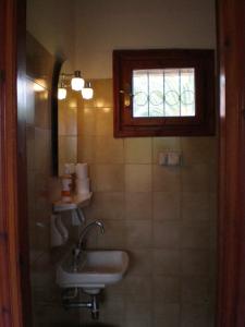 a bathroom with a sink and a window at Socrates Studios & Apartments in Acharavi