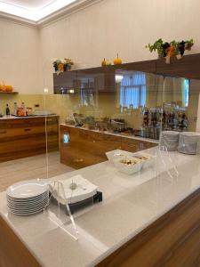 a kitchen with a counter with chairs and plates at Atlantic Terme Natural Spa & Hotel in Abano Terme