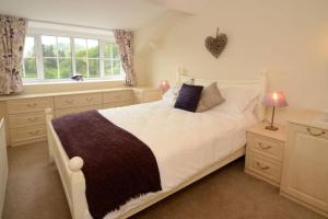 a bedroom with a large white bed and a window at Rosegate House, Elterwater in Elterwater