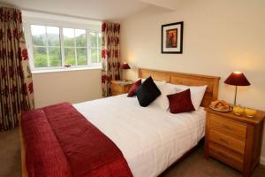 a bedroom with a large bed and a window at Rosegate House, Elterwater in Elterwater