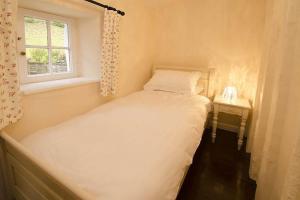 - une petite chambre avec un lit et une fenêtre dans l'établissement Speddy Cottage, Chapel Stile, à Chapel Stile