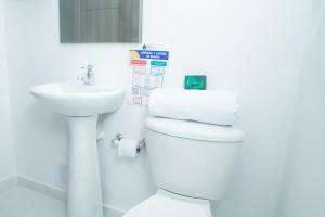 a bathroom with a white toilet and a sink at Hotel Ayenda House Concepción 1317 in Barranquilla +18 photos