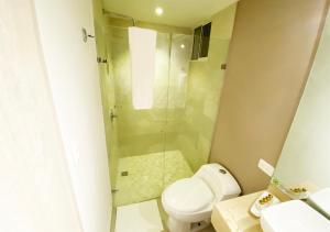 uma casa de banho com um chuveiro e um WC. em Hotel 1525 By GEH Suites em Santa Marta