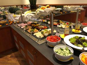 una línea de buffet con muchos tipos diferentes de comida en AVALON Hotelpark Königshof en Königslutter am Elm