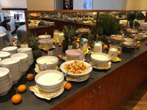 una línea de buffet con platos y tazones de comida en AVALON Hotelpark Königshof en Königslutter am Elm