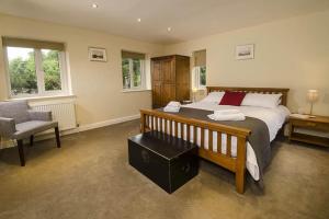 a bedroom with a large bed and a chair at The Parsonage, Ambleside in Ambleside