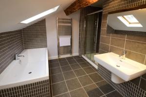 a bathroom with a sink and a tub and a mirror at The Parsonage, Ambleside in Ambleside