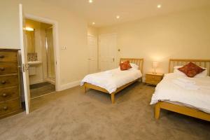 a bedroom with two beds and a mirror at The Parsonage, Ambleside in Ambleside