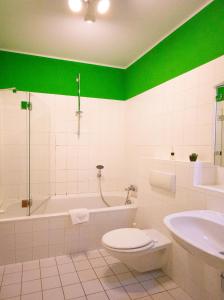 uma casa de banho com uma banheira, um WC e um lavatório. em Cozy Domicile Leipziger Auwald em Leipzig
