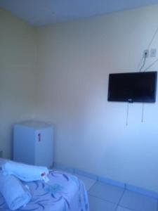 a room with a bed and a tv on a wall at Pousada Catamarã Anexo in Maceió