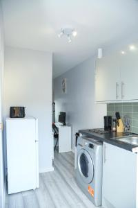 een keuken met een wasmachine en een wasmachine bij Wilmington Lodge Dartford London in Kent