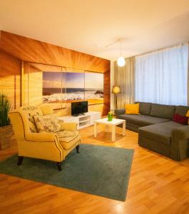 uma sala de estar com um sofá e uma cadeira e uma televisão em Cozy Domicile Leipziger Auwald em Leipzig