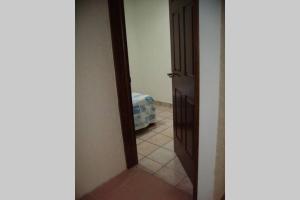 um corredor com uma porta e um quarto com uma cama em Casa cerca del centro de Morelia em Morelia