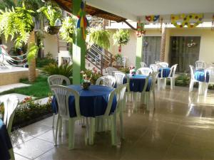 een groep tafels en stoelen met blauwe tafelkleden bij Pousada Paraíso das Palmeiras in Paripueira