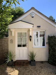 una casa con una puerta blanca y dos plantas en Thorn House B&B en Fen Drayton